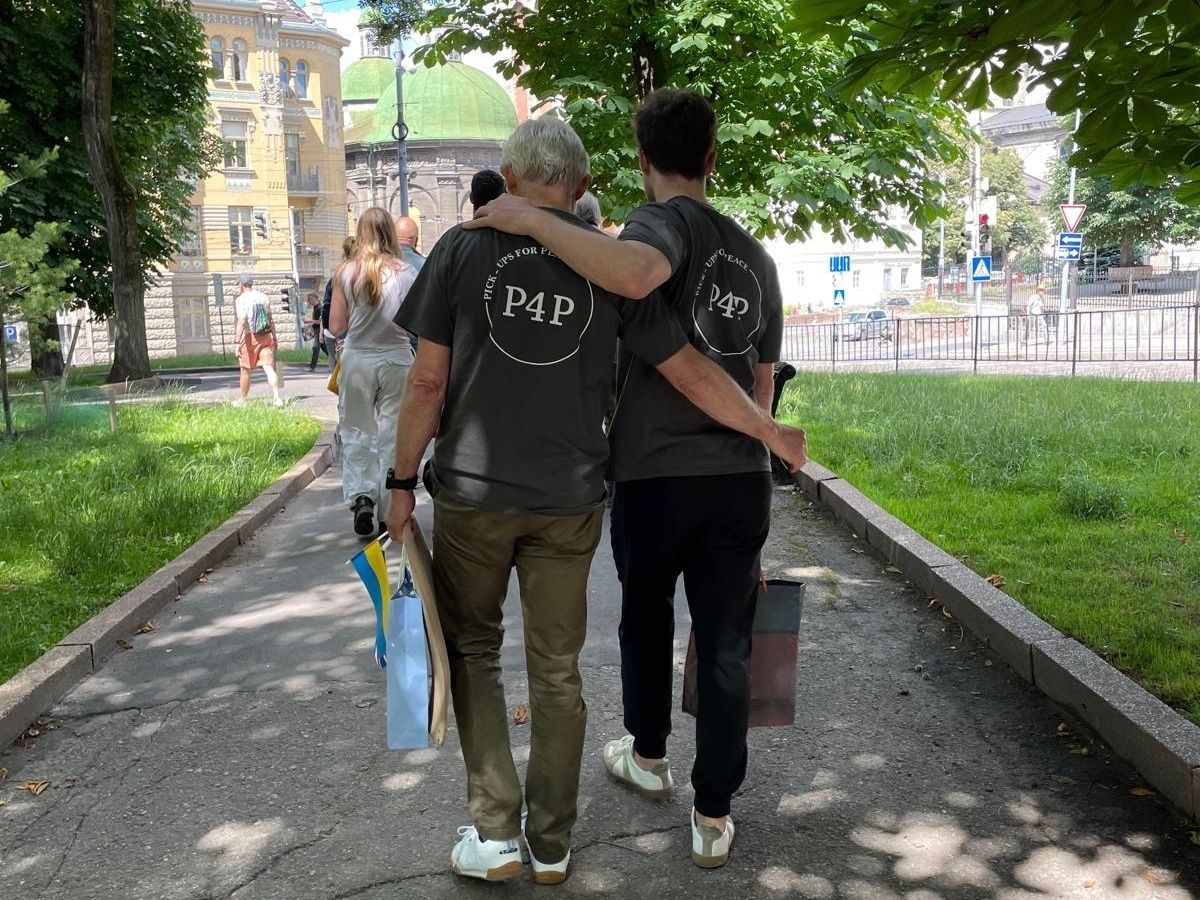 Twee konvooirijders in Pickups for Peace-shirt, van achteren gezien